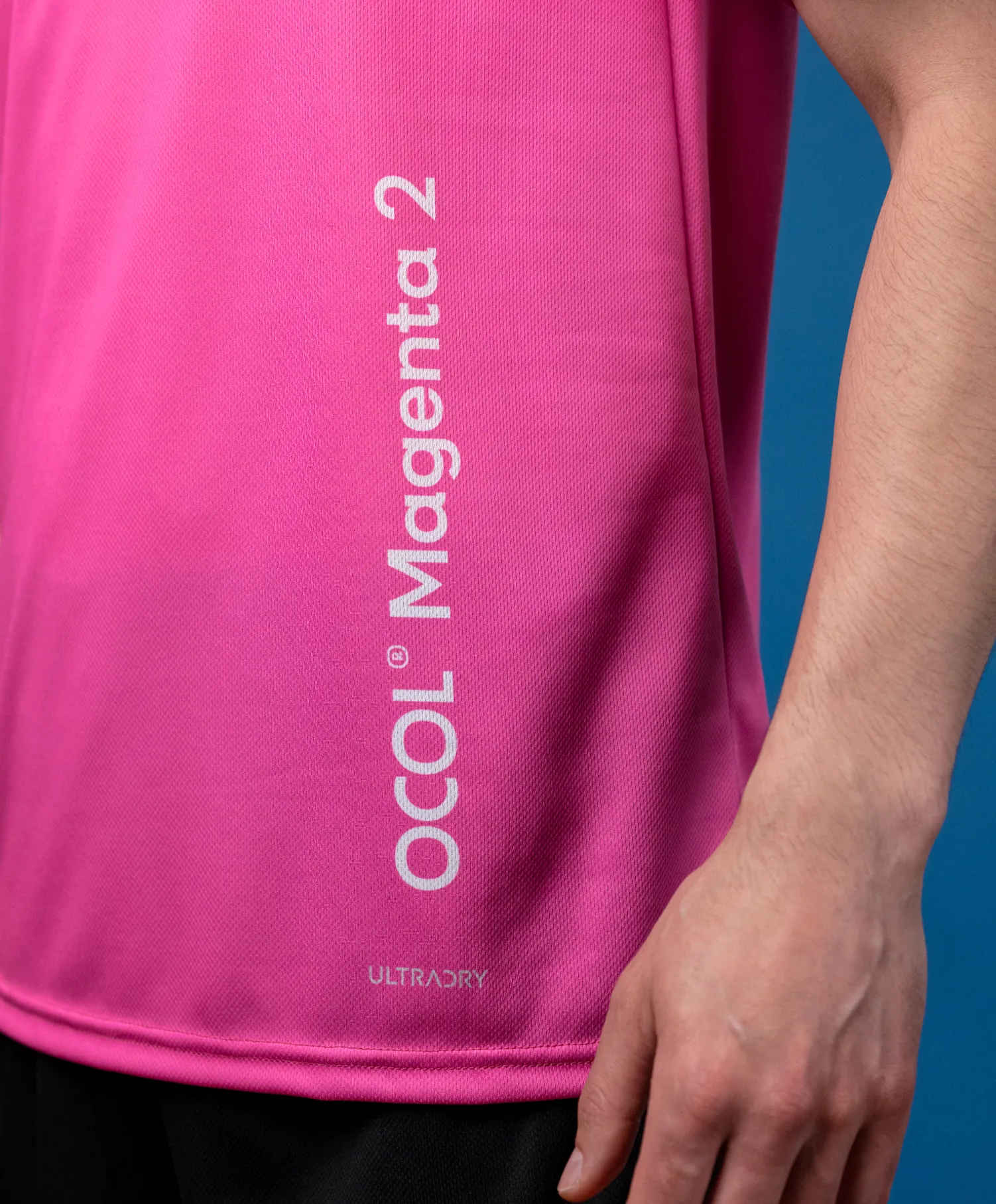 Een roze sporttop met een logo en de tekst 'Magenta 2'.