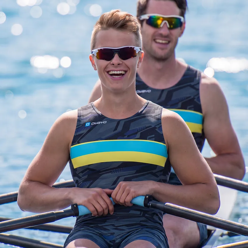 Twee roeiers in een boot dragen stijlvolle, op maat gemaakte sportkleding met een modern patroon en levendige kleuren.